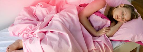 Bilde av en ung kvinne som ligger i sengen hennes. Bildet illustrerer at du kan bruke tamponger i løpet av natten og ikke trenger å bekymre deg for menstruasjon.